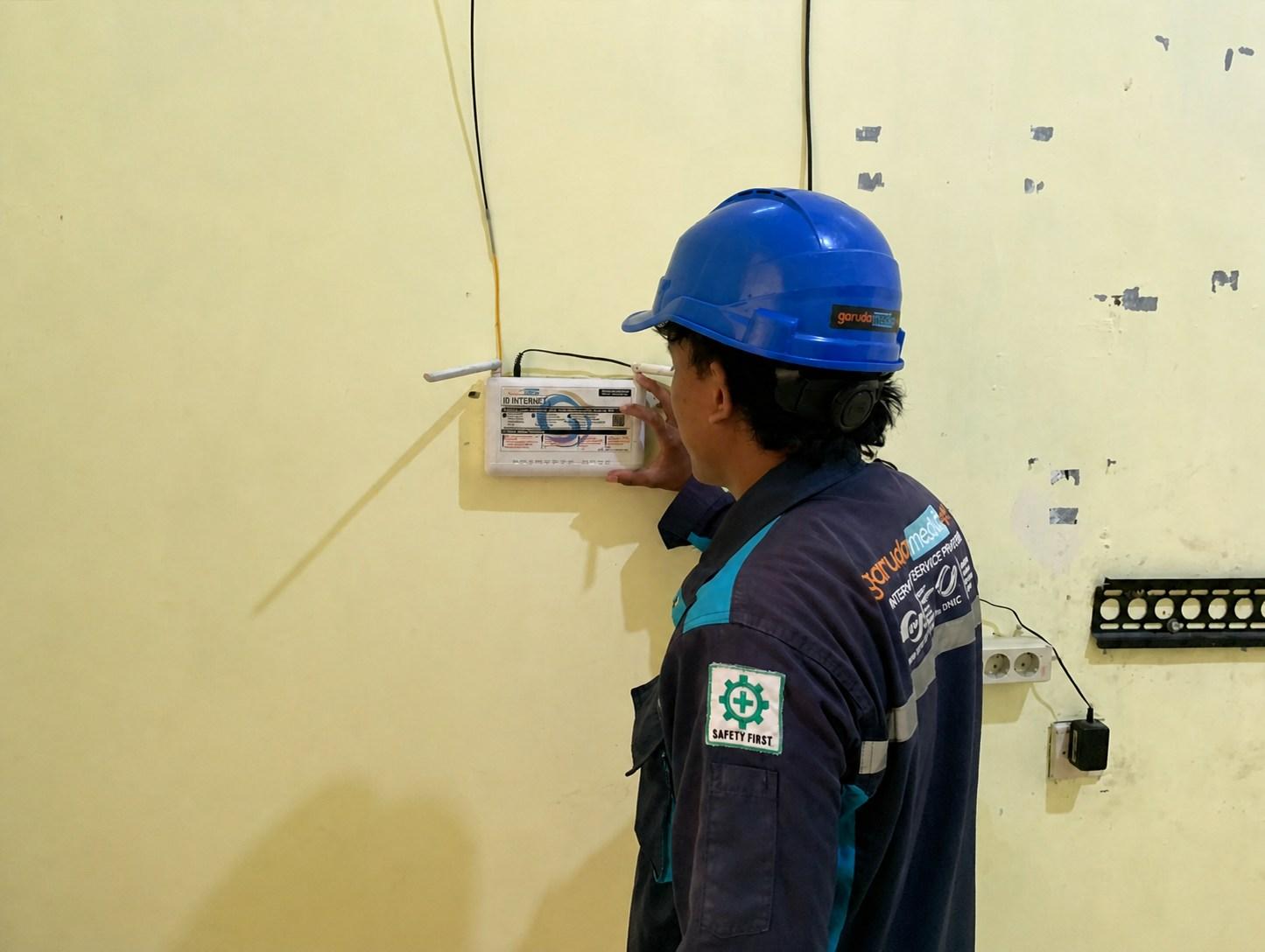 Teknisi Garuda Media Telematika 20 memasang perangkat internet di lokasi pelanggan